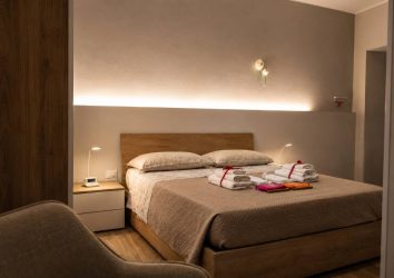 Camera matrimoniale con letto in legno e luci soffuse - B&B La Corte Montesarchio